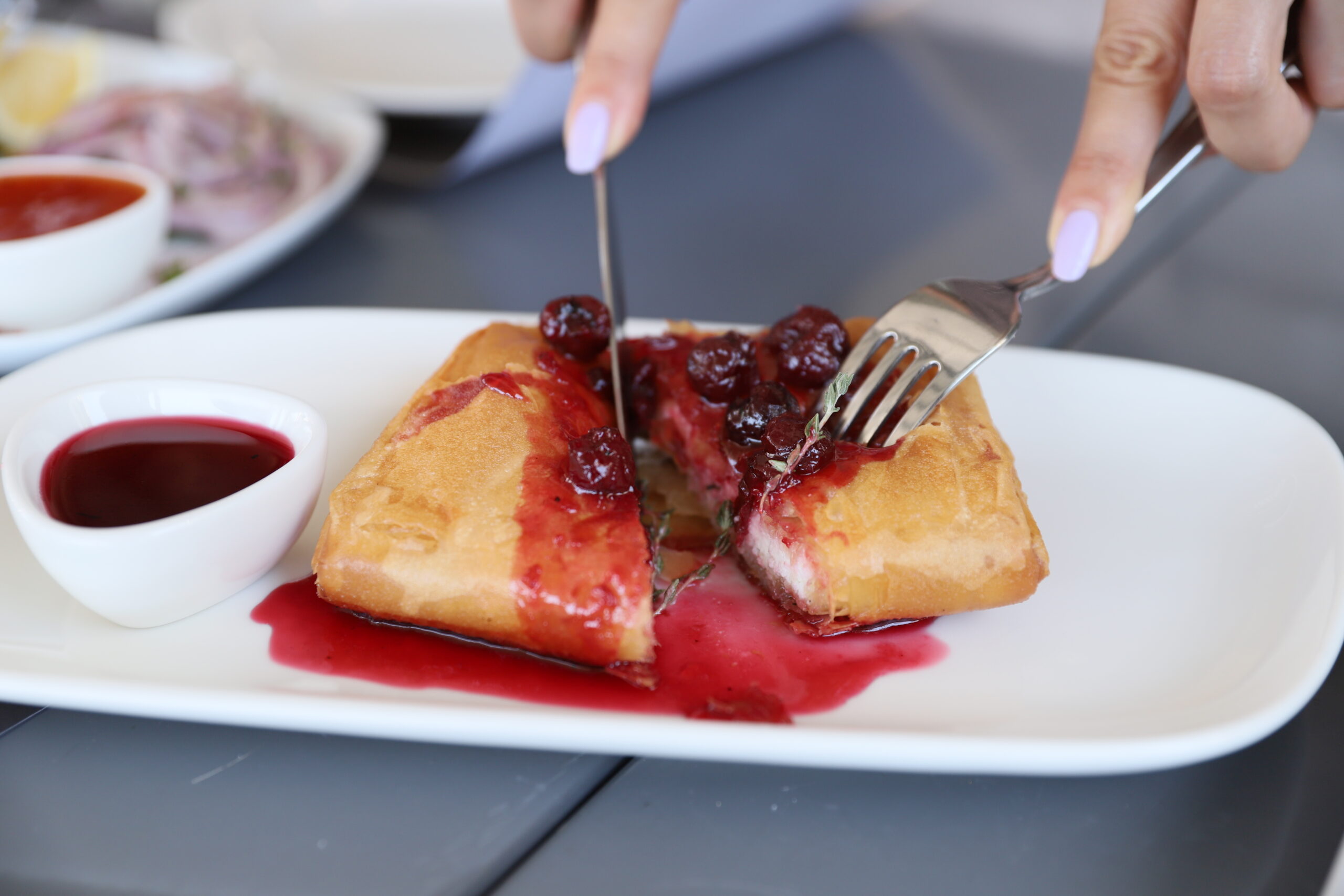 Feta cheese rolled with a pie crust and Riviera cherry sauce